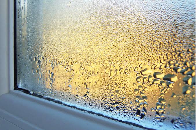 Condensation sur une fenêtre de salon en automne, signe d'un taux d'humidité trop élevé
