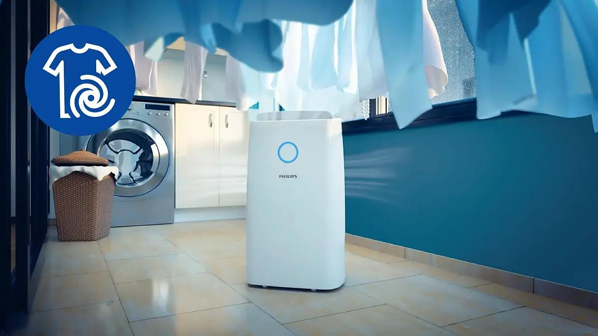 Linge séchant sur un étendoir à côté du déshumidificateur Philips DE3306 en mode séchage